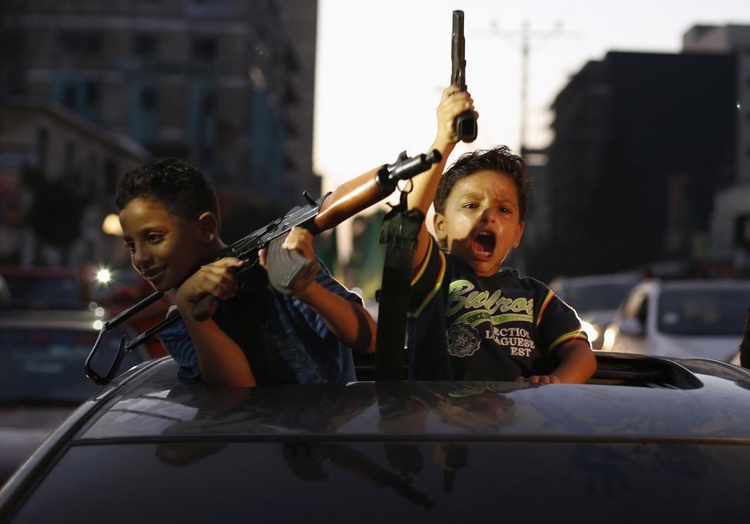 fot. Suhaib Salem / Reuters / 26 sierpnia 2014  Gaza, Palestyna  Palestyńskie dzieci z bronią palną świętują “zwycięstwo” nad Izraelem - okres zawieszenia ognia.